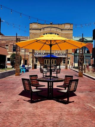 Downtown Negaunee on a sunny day looking at a table and chairs with an umbrella